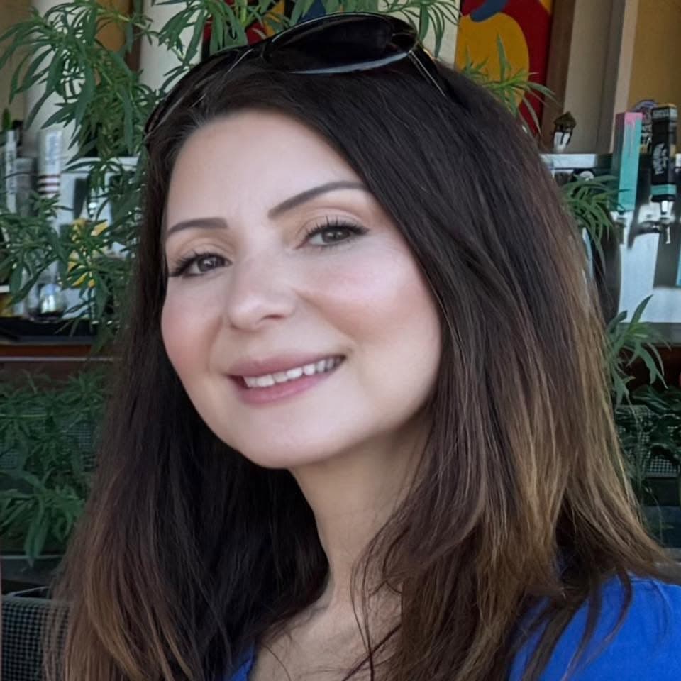 Patricia Herrera smiling in a portrait with plants in the background